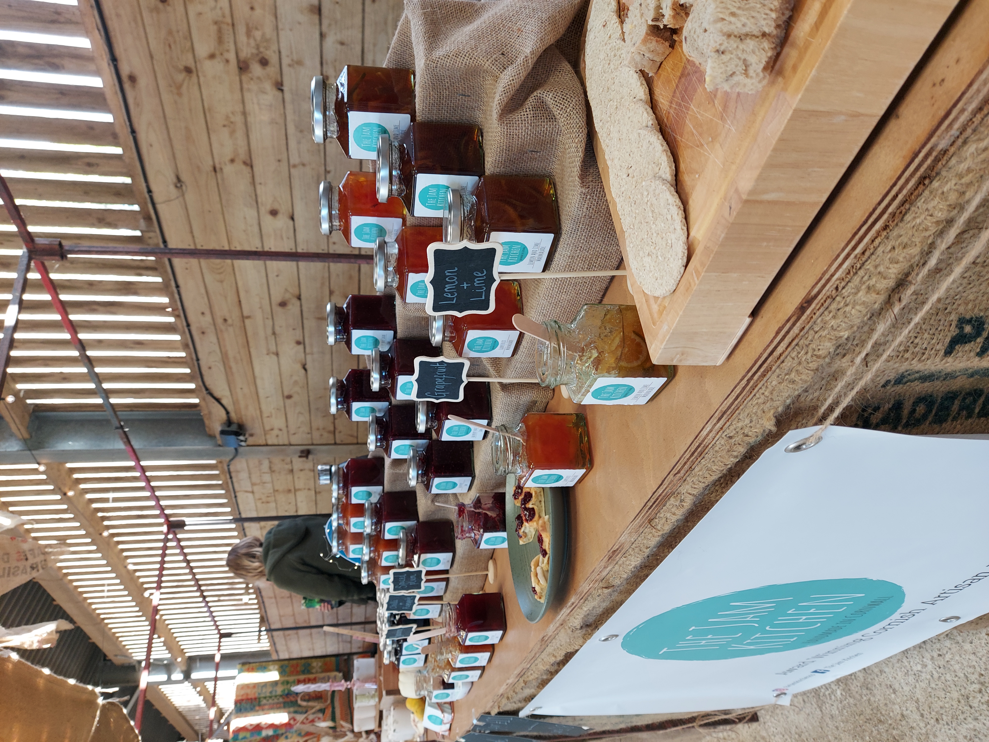 The Jam Kitchen market stall with jars of handmade Cornish preserves displayed alongside crackers for sampling